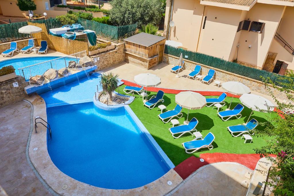 卡拉博纳Sol y Mar Apartments的享有带椅子和遮阳伞的游泳池的上方景色