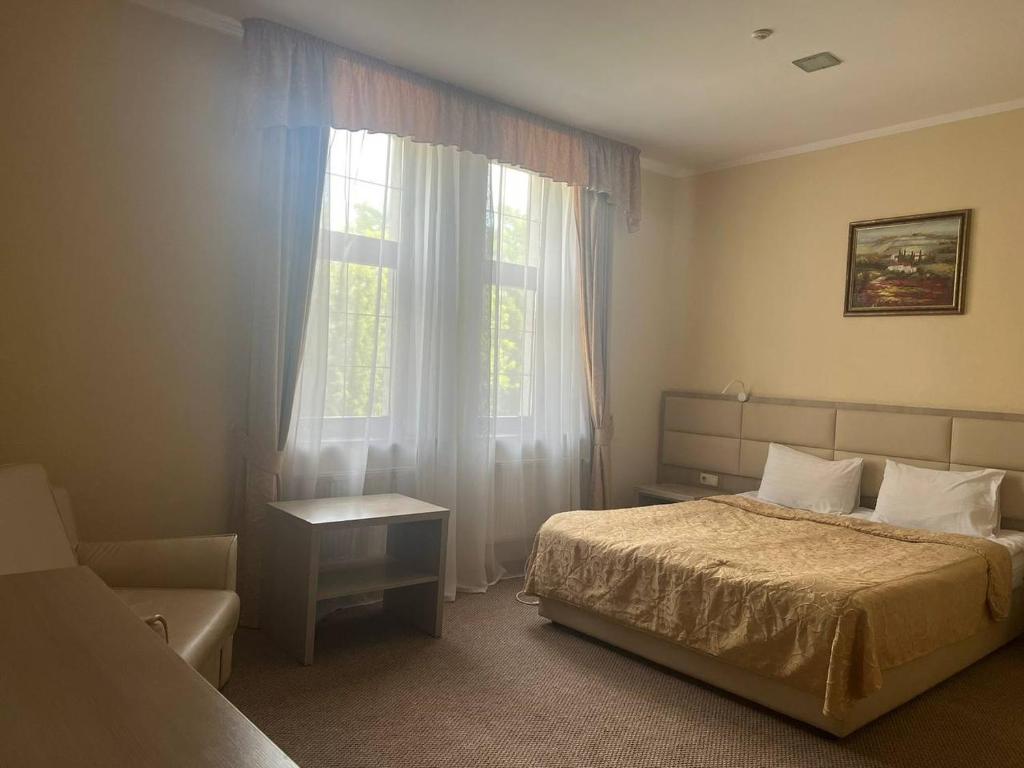 鲍里斯皮尔利吉纳酒店的一间卧室设有一张床和一个窗口
