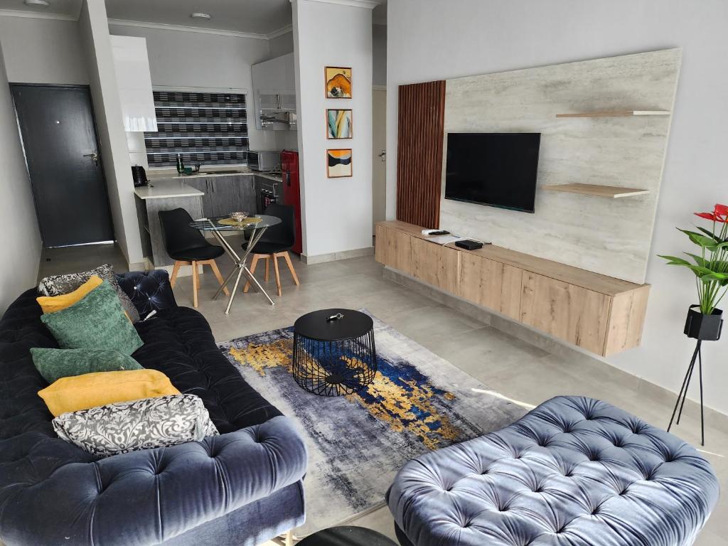 哈博罗内SaronaC102的带沙发和电视的客厅