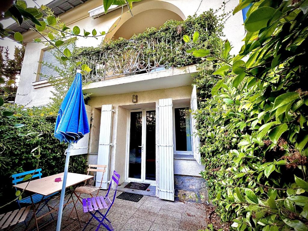 戛纳Villa Etoile Cannes的一个带桌子和蓝伞的房子