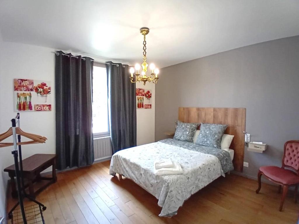 卡尔艾普卢盖VILLA CLARETTE的一间卧室配有一张床、一把椅子和一个吊灯。