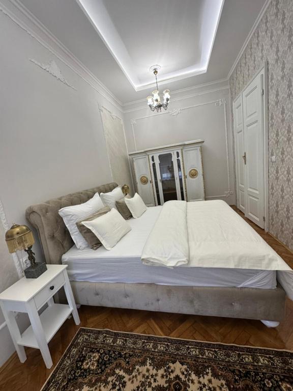 松博尔Apartments & Room - Korzo的白色卧室配有一张大床和吊灯