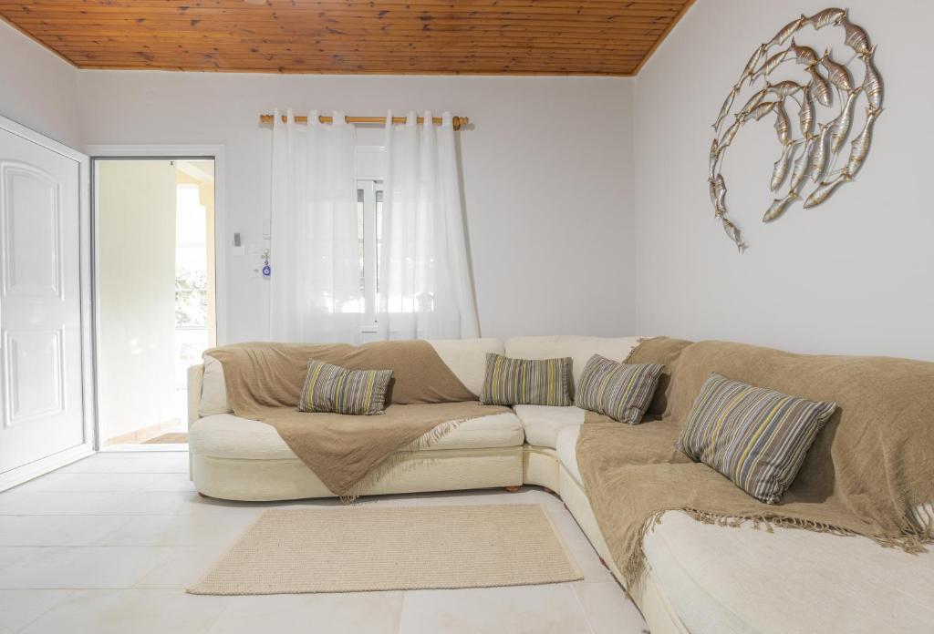 库鲁塔KOUROUTA BEACH HOUSE的白色的客厅配有沙发和窗户