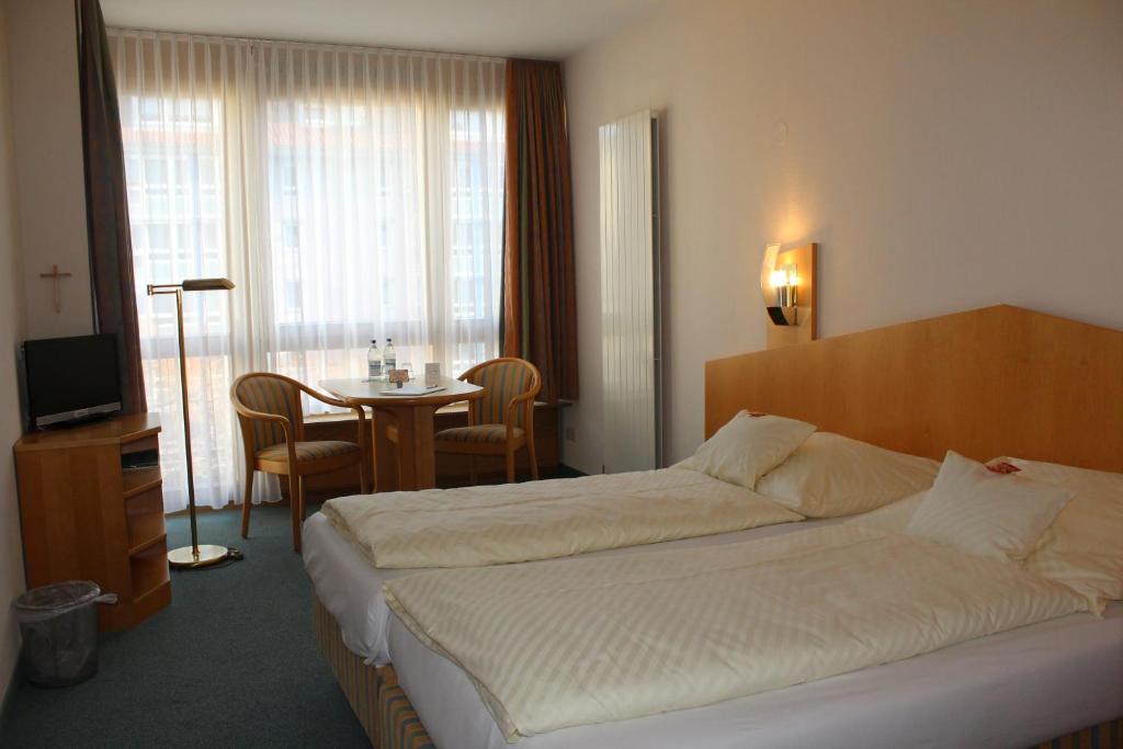 斯图加特Evangelische Diakonissenanstalt Stuttgart的酒店客房配有一张床铺和一张桌子。