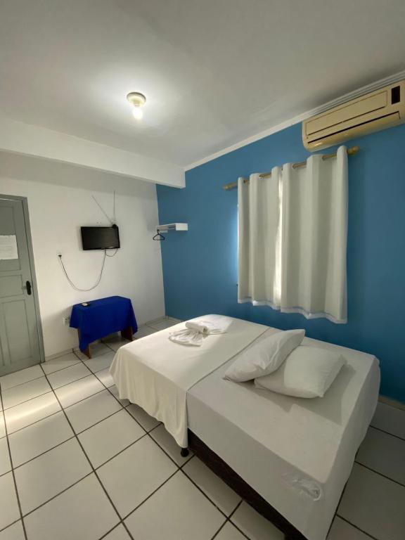 卡马穆Pousada o Paraiso的一间卧室设有蓝色的墙壁和一张床