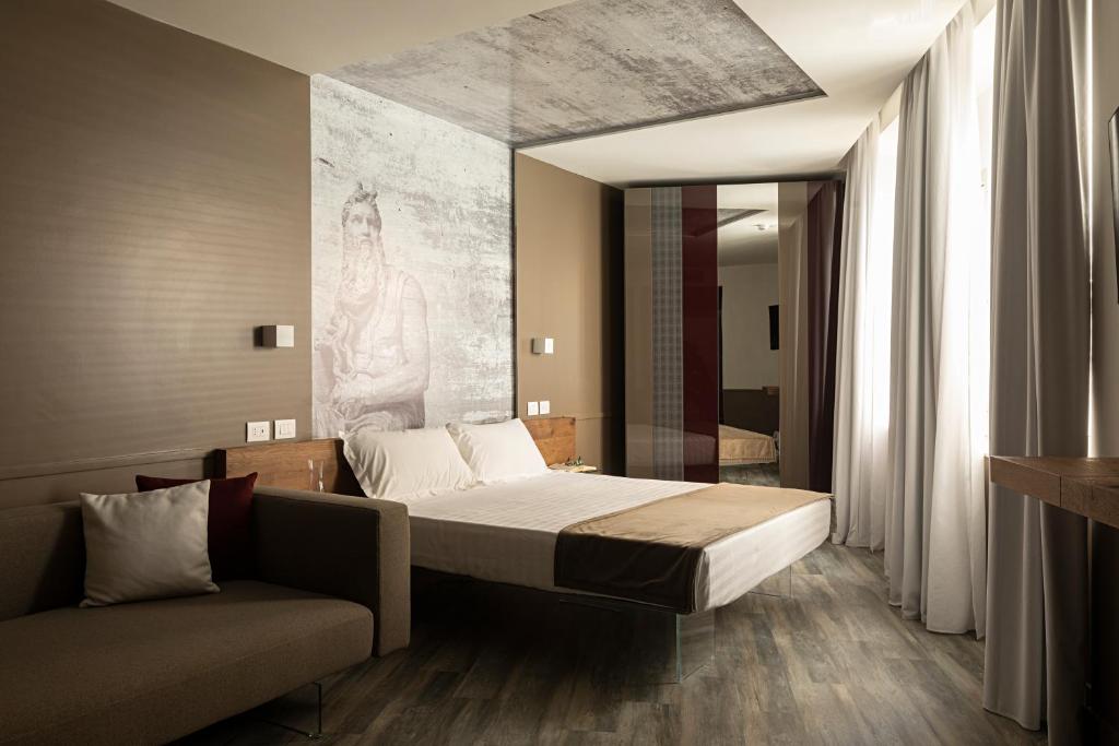 罗马内葛诺酒店的一间卧室配有一张床和一张沙发