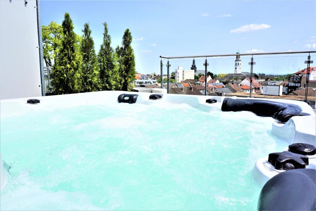 法兰肯塔尔Panorama Penthouse Apartment Whirlpool für 6 Personen的配有蓝色水的按摩浴缸