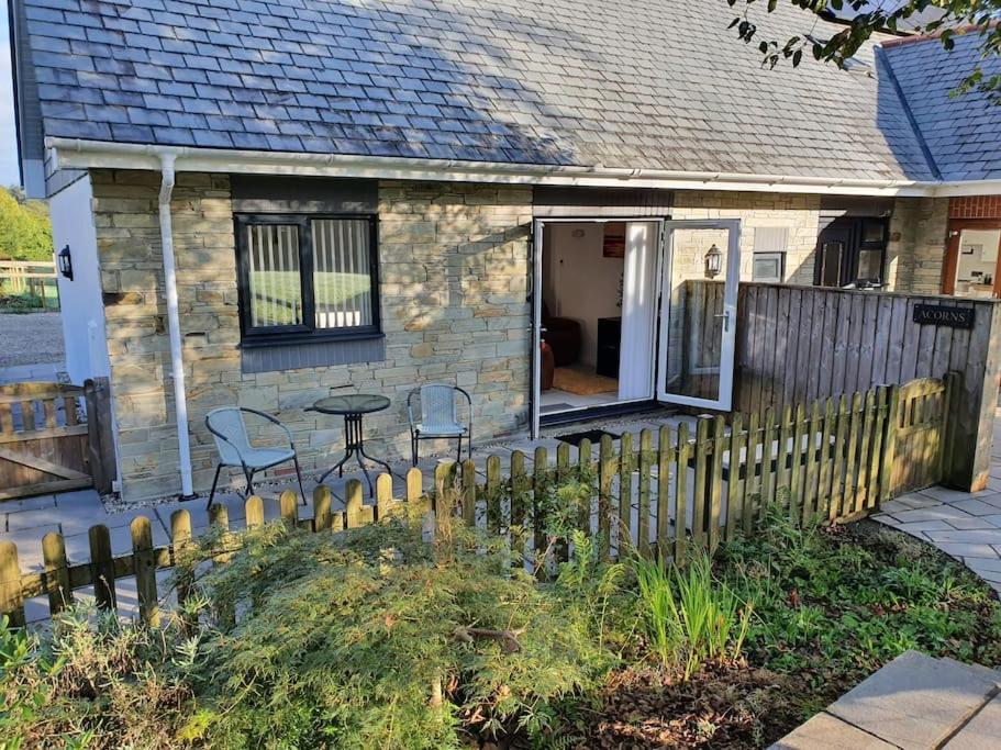 卡林顿Modern, self-contained annexe in the countryside的一栋带围栏和桌椅的小房子
