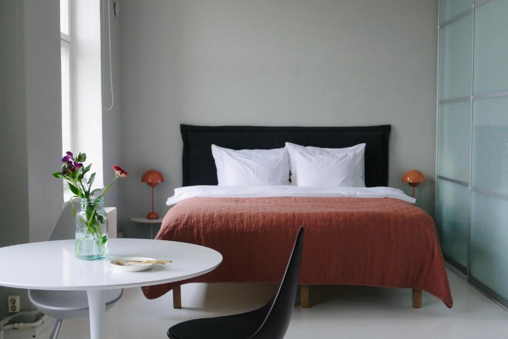 赫尔辛基Kruna by the Sea的卧室配有一张带白色桌子和白色桌丝绸 ⁇ 的床。