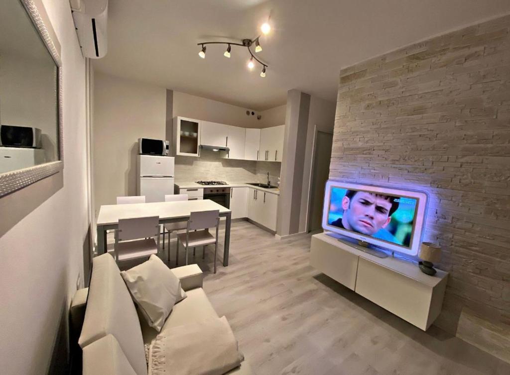 洛萨皮内塔[SolMare] Apartments - Private parking - Pool的一间客厅,在砖墙上配有电视