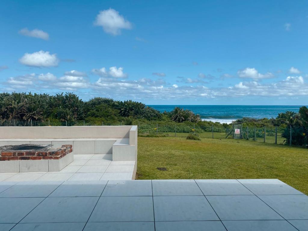 爱德华港Tamassa Holiday Home on the Beach, in Port Edward的海景庭院内的壁炉