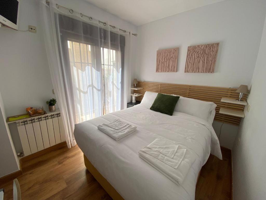 Habitación intima con patio privado的卧室配有一张白色大床和两条毛巾