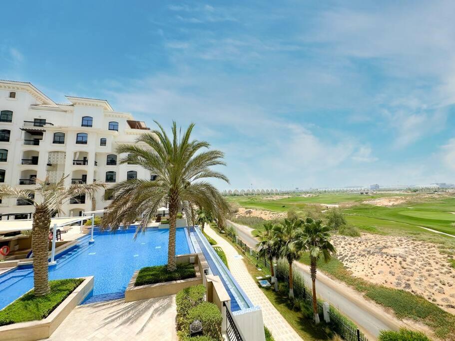 阿布扎比Luxury Golf View For Family 203A3的享有酒店游泳池和棕榈树的景色