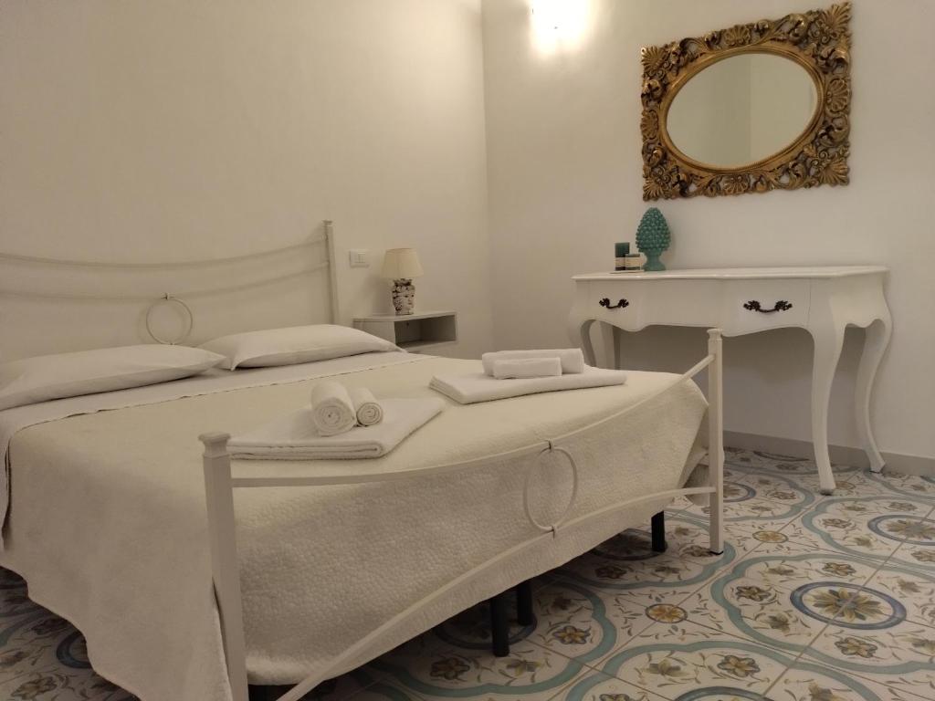 米拉佐Dimora d'Estate (Sicilian Holidays)的白色卧室配有床和镜子