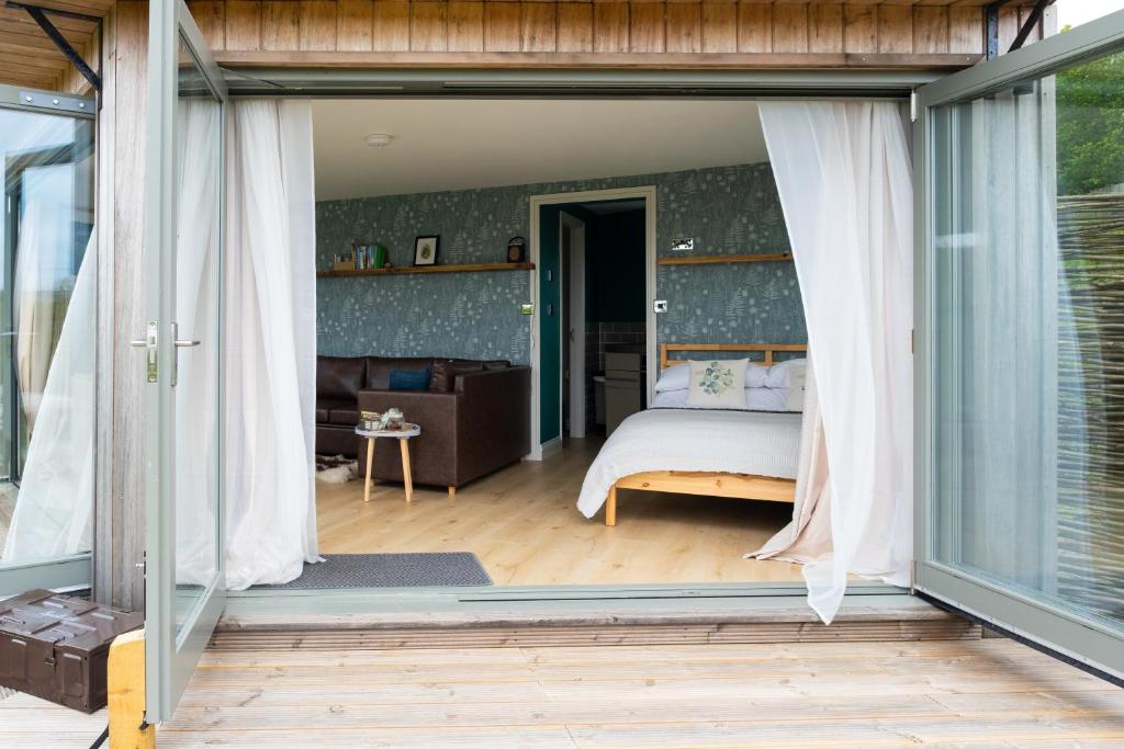 海伯敦桥Daisy Bank Camp的一间卧室设有床和滑动玻璃门