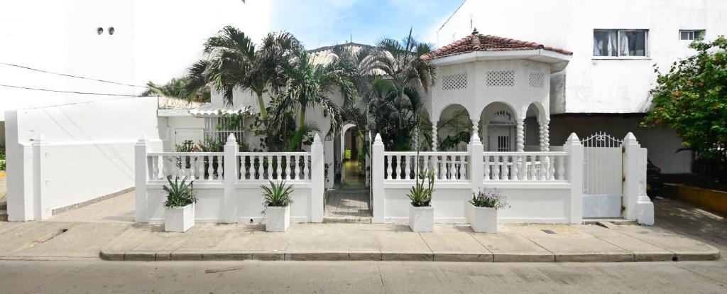 卡塔赫纳Casa Hotel Terraza del Cabrero的盆栽植物屋前的白色围栏