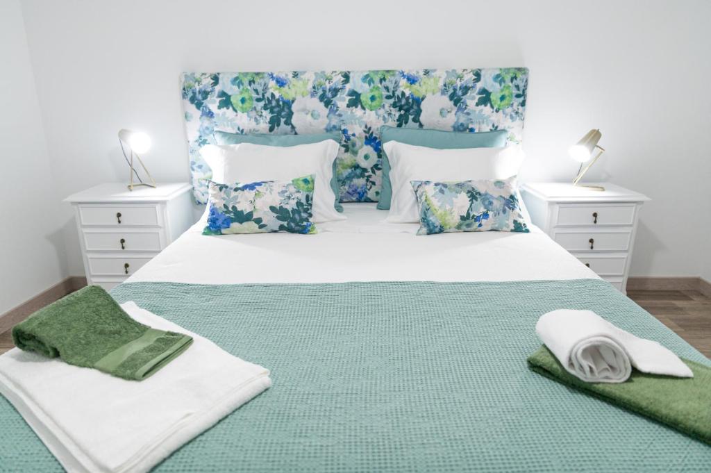 圣若昂达佩什凯拉Casa Milita的一间卧室配有一张带绿毯和枕头的床。