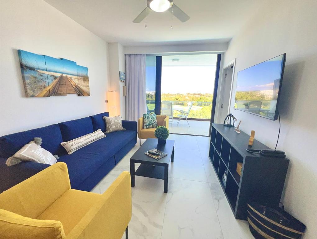 蓬塔卡纳Cana Rock Star, Apartamento Lujo Vista Golf Infinity Pool A-410的客厅配有蓝色的沙发和桌子