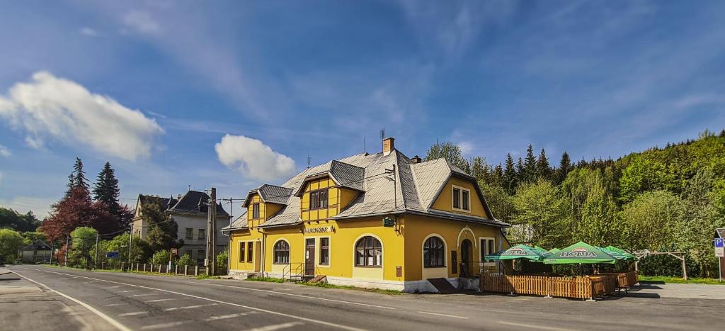 小莫拉夫卡Penzion U Kovárny的坐在街道边的黄色房子