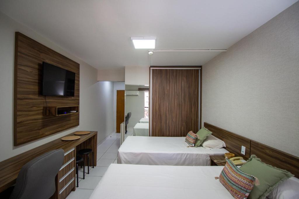 巴西利亚Garvey Park Hotel的酒店客房设有两张床和电视。