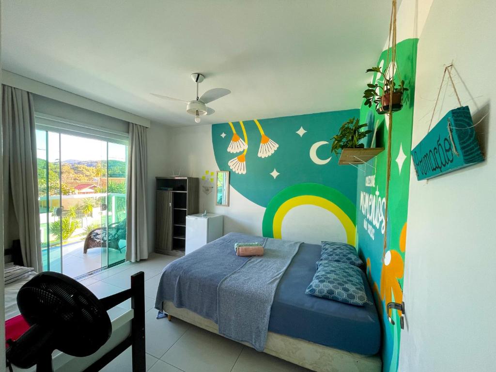 塞尔苏拉穆斯州长镇Ipê Palmas Hostel的一间卧室设有一张床和彩虹墙