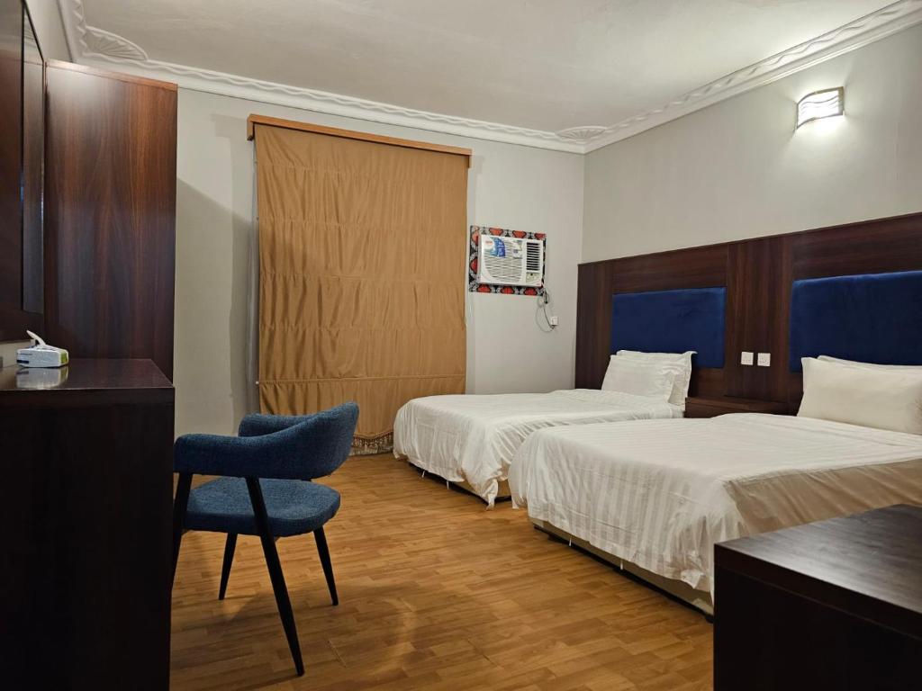 延布Safa PARK HOTEL YANBU فندق صفا بارك ينبع的酒店客房,配有两张床和椅子