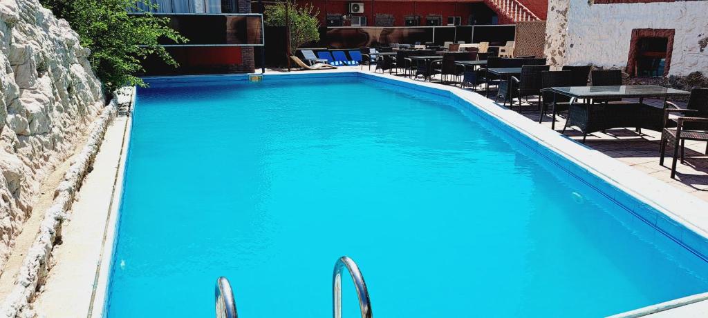 巴库Mardin Hotel Novxanı的一个带桌椅的大型蓝色游泳池
