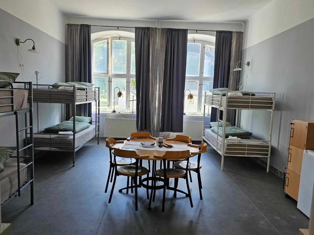 AxvallStora Ekeberg vandrarhem的客房设有桌椅和双层床。