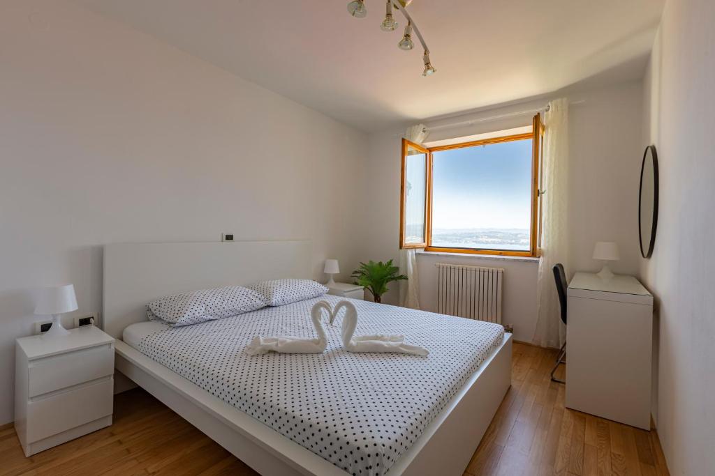 科佩尔Villa Andrea的一间白色的卧室,配有一张带两个天鹅的床