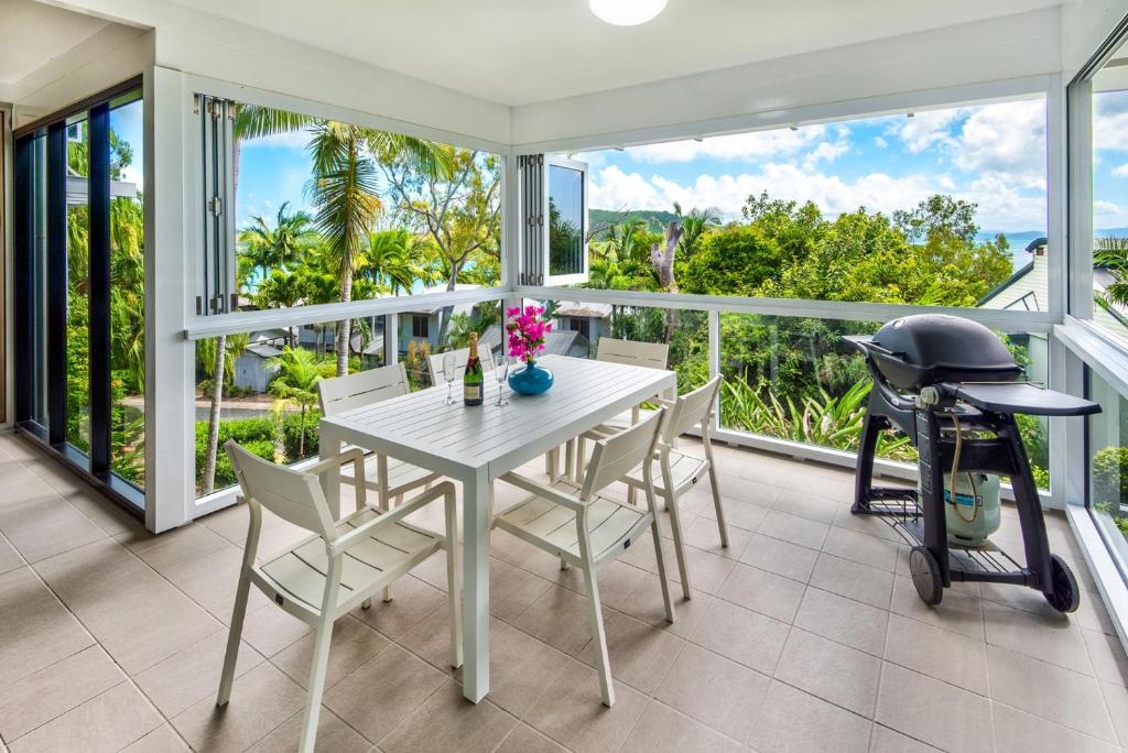 汉密尔顿岛Escape to Paradise at Oasis 1, a 2BR Central Hamilton Island Apartment with Buggy!的一间带桌椅和摩托车的用餐室