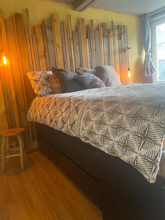 雅莱au 39的一间卧室配有一张带木制床头板的床