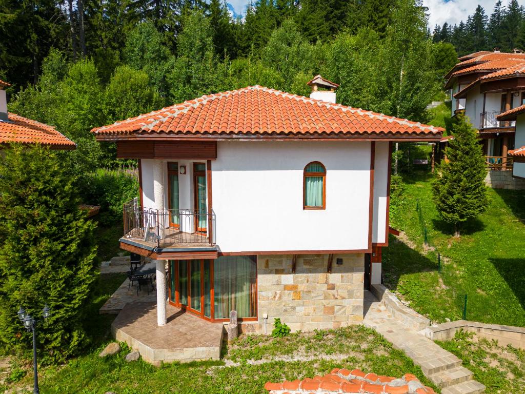 潘波洛沃Pamporovo Cottage Savov的一座白色的小房子,拥有橙色的屋顶