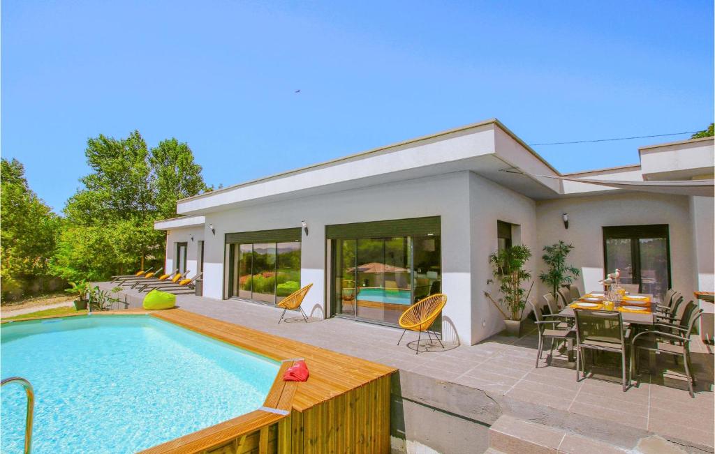 蒙特利马尔Amazing Home In Montlimar With Outdoor Swimming Pool的一座带游泳池和桌椅的房子
