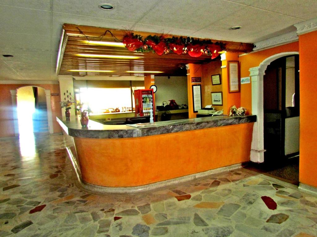 内瓦HOTEL DINASTIA REAL NEIVA的餐厅内拥有橙色墙壁的酒吧