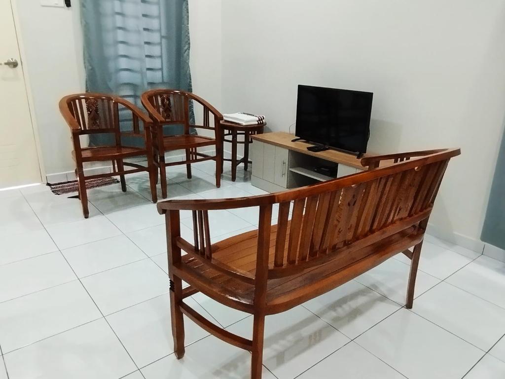 马六甲Mukmin 2 Stay的一间设有四把椅子和一张带笔记本电脑的长凳的房间