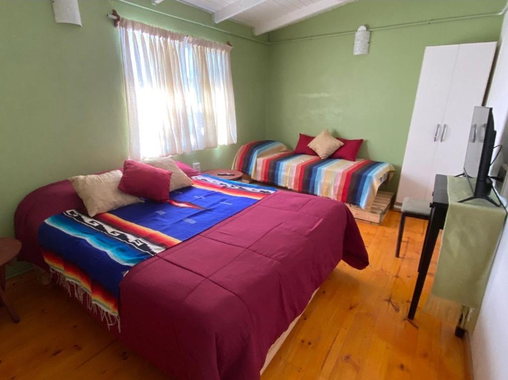 伊瓜苏港Mary's House的一间卧室配有两张床和电视。