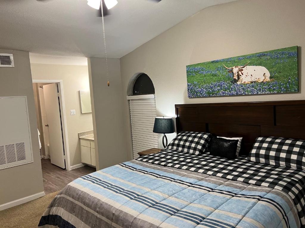 休斯顿Beautiful 1-bedroom Townhome with nice amenities的卧室配有一张床,墙上挂着牛油画