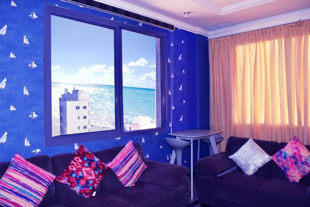 科威特Hotel Leaders Plaza Salmiya的带沙发和大窗户的客厅