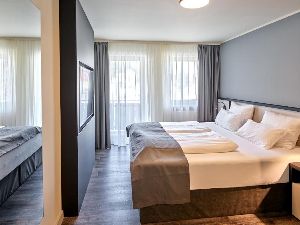 帕绍Hotel Innsento - Health Campus Passau的酒店客房设有一张大床和窗户。