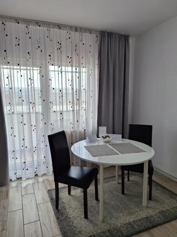 克卢日-纳波卡FARMEC Apartament的一间配备有白色桌子和两把椅子的用餐室