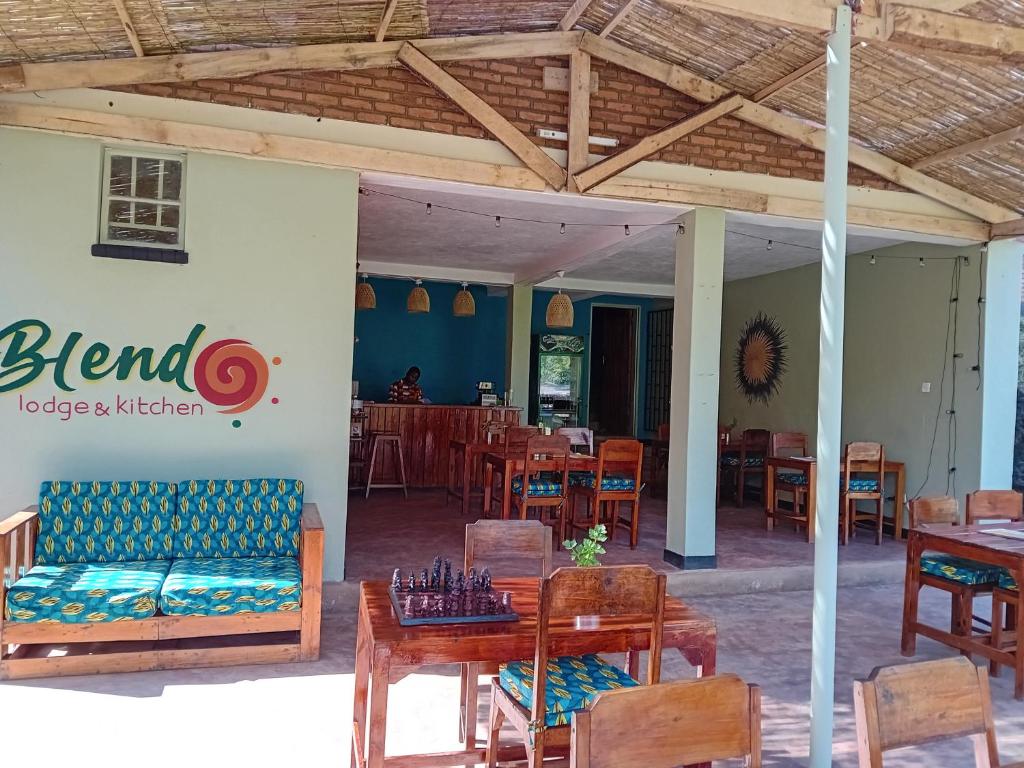 ZombaBlend Lodge and Kitchen - Pakachere的餐厅设有木桌、椅子和标志