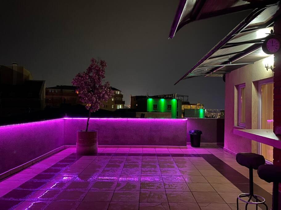 普里什蒂纳Siera's Penthouse的建筑一侧的紫色灯房