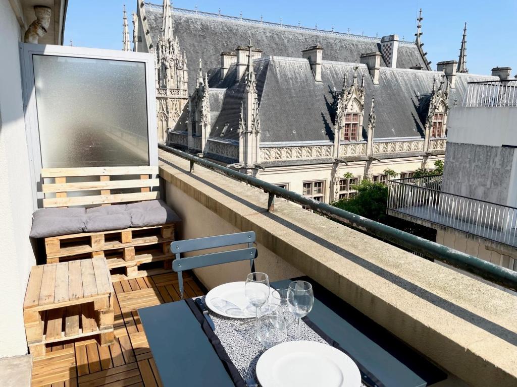 鲁昂Appartement A Deux Pas situé en Hyper Centre Ville的阳台享有建筑景致,配有桌椅。