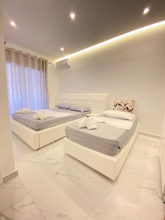 卡萨米尔Villa Mucodemi 1的白色墙壁客房的两张床