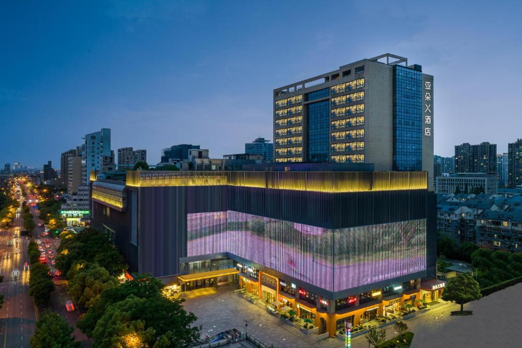 杭州杭州文一路亚朵X酒店的一座城市中带灯面的大型建筑