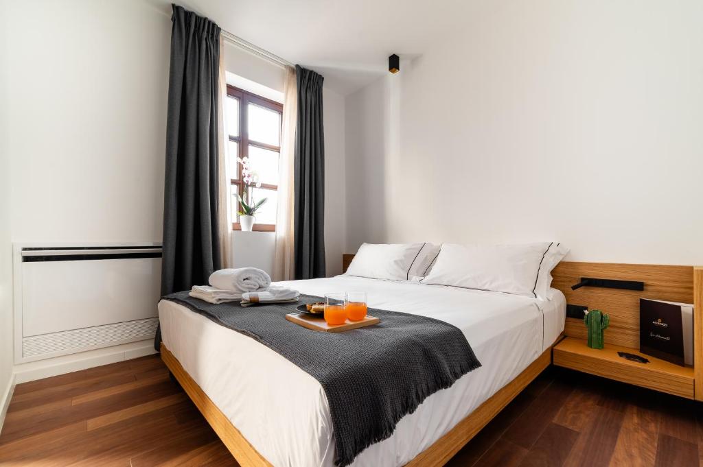 孔韦尔萨诺Arringo - Stay comfy的一间卧室,配有一张床,上面放着橙子托盘