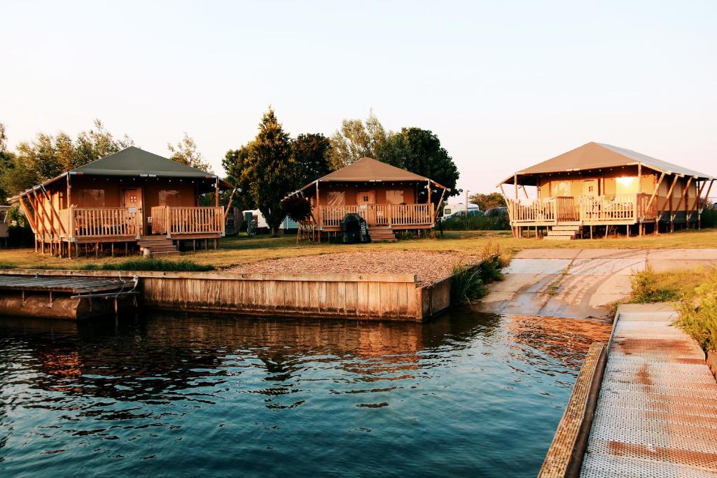 AlphenLuxury Lake Lodge的水体旁的几栋小屋