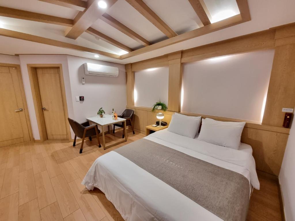 首尔LEX旅游酒店 的一间卧室配有一张大床和一张桌子