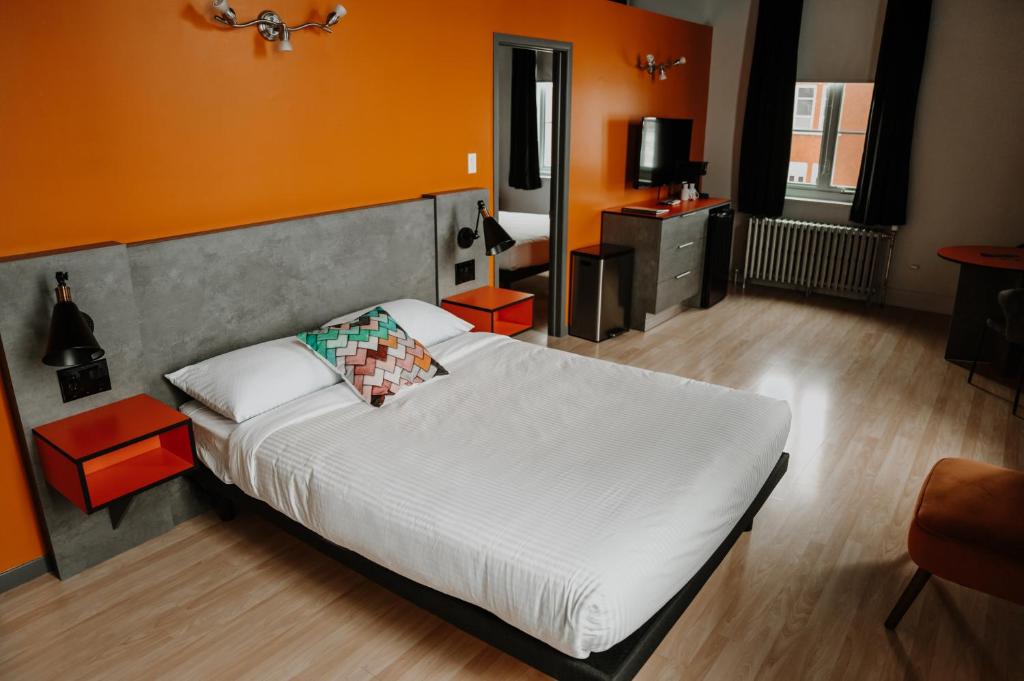 Saint-VictorHotel Historique et Manoir Route 66的卧室配有白色的床和橙色的墙壁