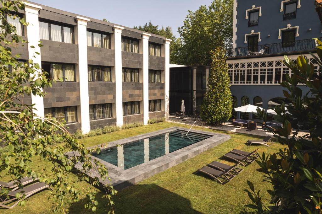 圣伊拉里奥-萨卡尔姆巴尔内阿里奥方特别墅酒店-仅限成人入住的建筑前带游泳池的庭院